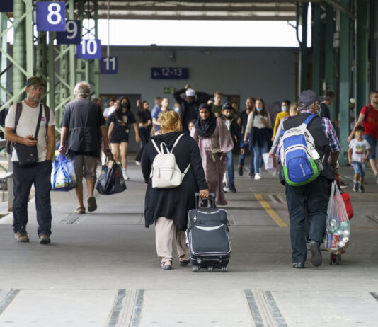Menschen laufen mit Reisegepäck über den Hauptbahnhof