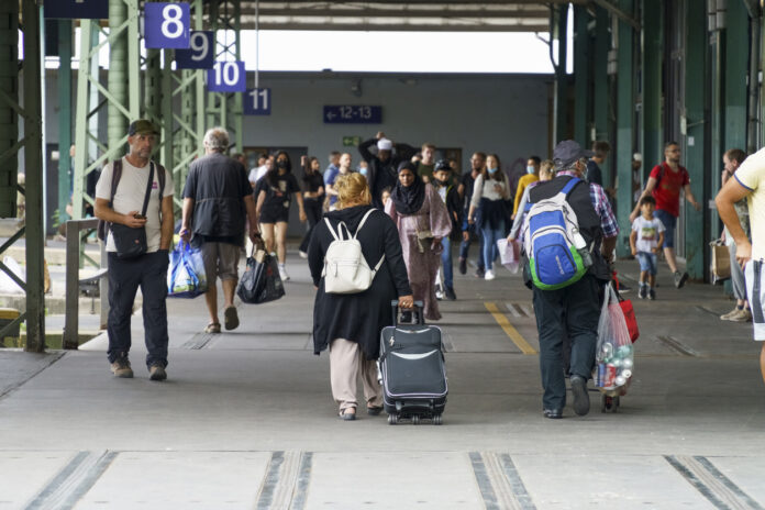 Menschen laufen mit Reisegepäck über den Hauptbahnhof