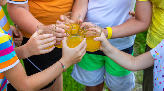 Kinder trinken Orangenlimonade