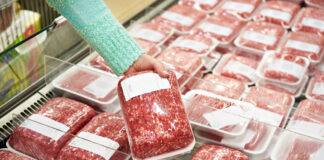 Käufer-Frau wählt gehacktes Fleisch im Supermarkt