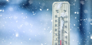 Thermometer mit niedrigen Temperaturen steht im Schnee