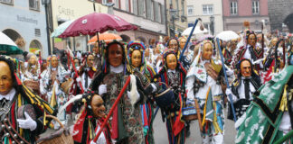 Ein traditioneller Faschingsumzug mit Maskierten und kostümierten Teilnehmern.