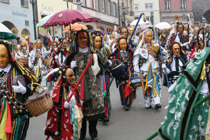 Ein traditioneller Faschingsumzug mit Maskierten und kostümierten Teilnehmern.