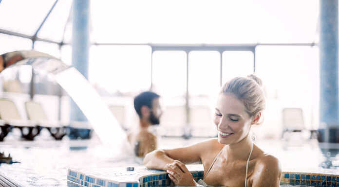 Eine Frau entspannt sich im Pool und genießt ihre Auszeit.