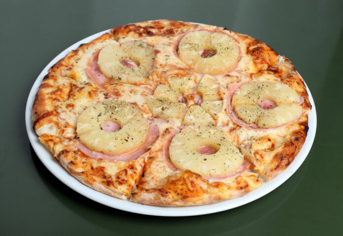 Eine Pizza Hawaii, die mit Ananas belegt ist