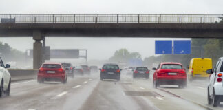Autos fahren bei schlechtem Wetter auf einer Autobahn unter einer Autobahnbrücke