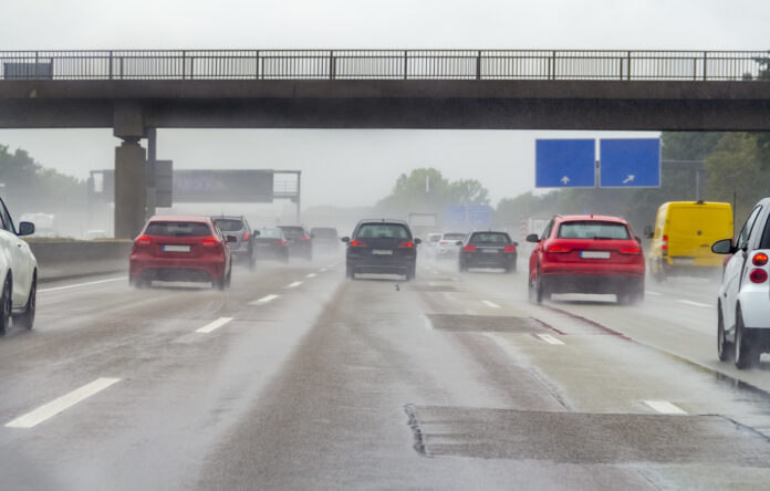 Autos fahren bei schlechtem Wetter auf einer Autobahn unter einer Autobahnbrücke