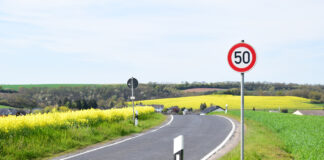 Ein Tempolimit 50 Schild steht in der Kurve einer Landstraße