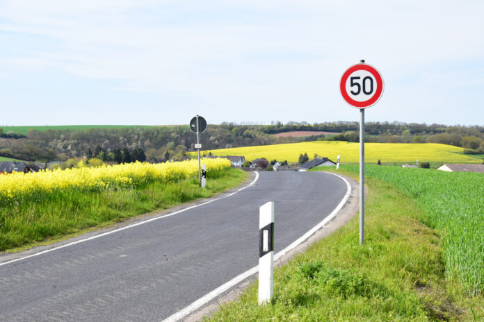 Ein Tempolimit 50 Schild steht in der Kurve einer Landstraße
