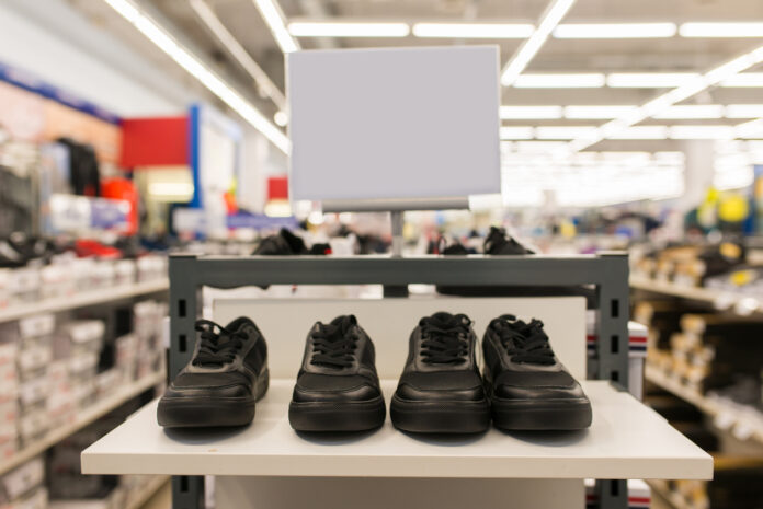 Schwarze Sneaker oder Turnschuhe stehen in einem Schuhgeschäft auf dem Regal