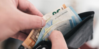Blick in einen Geldbeutel mit Geldscheinen. Eine 10-Euro-Münze soll ein Vermögen wert sein. Bald soll es eine Zahlung für Bürgergeld-Empfänger geben.