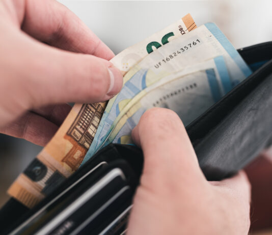 Blick in einen Geldbeutel mit Geldscheinen. Eine 10-Euro-Münze soll ein Vermögen wert sein. Bald soll es eine Zahlung für Bürgergeld-Empfänger geben.