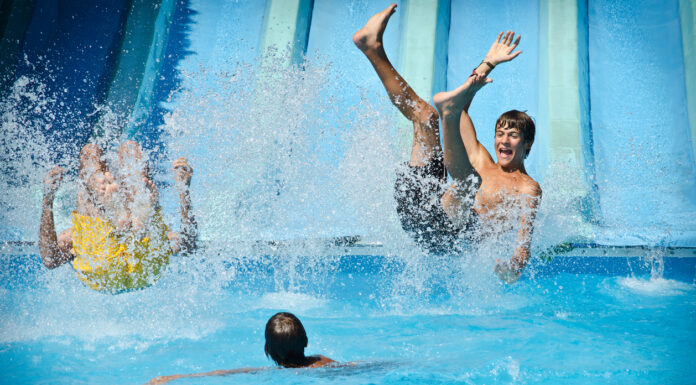 Junge Menschen haben Spaß im Wasser. Ein neues Schwimmbad hat eröffnet.