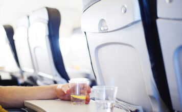 Ein Glas Wasser steht auf einem Tisch in einem Flugzeug