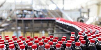 Getränke fahren in einer Produktionshalle auf einem Fließband in Flaschen