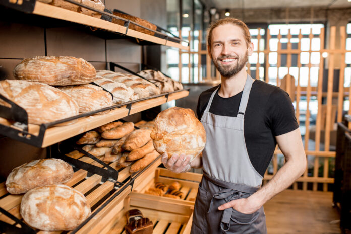 Ein Mitarbeiter hält ein Brot in der Hand