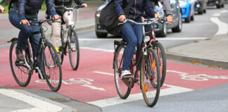 Fahrradfahrer fahren auf dem Fahrradweg durch die Stadt