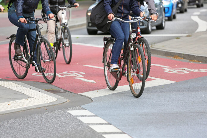Fahrradfahrer fahren auf dem Fahrradweg durch die Stadt