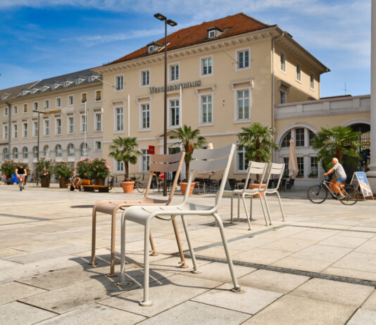 Der Marktplatz in Karlsruhe bei Sonnenschein, in der Mitte stehen Stühle