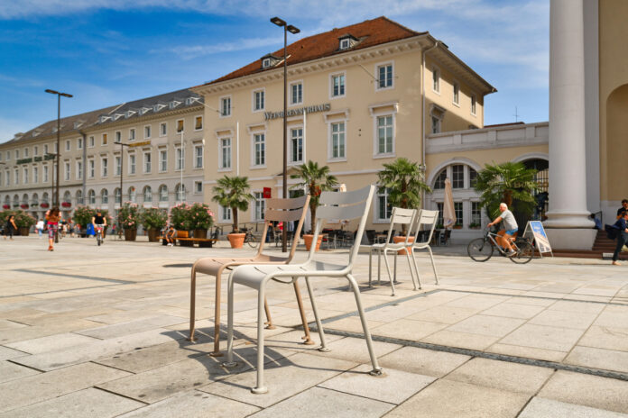 Der Marktplatz in Karlsruhe bei Sonnenschein, in der Mitte stehen Stühle