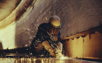 Ein Mann arbeitet mit einer Maschine und schneidet Metall