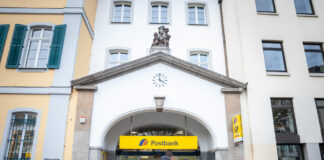 Großes weißes Gebäude mit Postbank-Logo und Briefkästen daneben. Einige Postbank-Filialen mussten schließen.