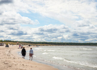 Menschen laufen am Meer am Strand entlang