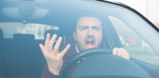 Ein wütender Autofahrer sitzt im Auto