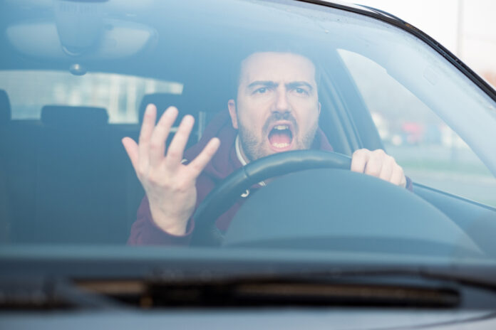 Ein wütender Autofahrer sitzt im Auto