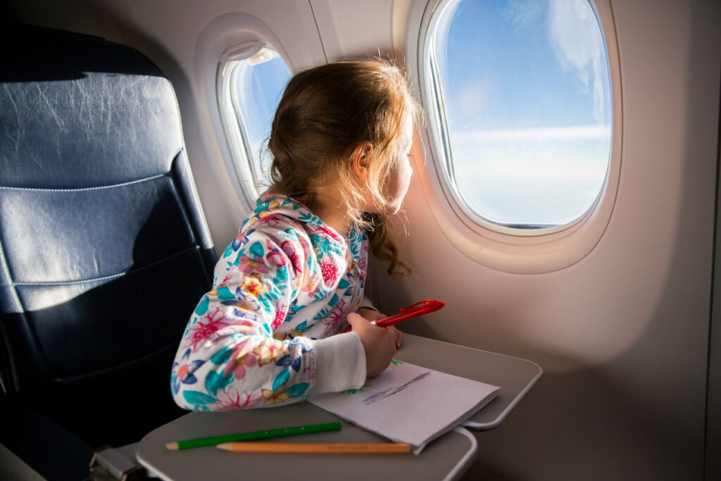 Im Flugzeug kann es für Kinder schnell langweilig werden. Deshalb sollte man unbedingt für Unterhaltung sorgen.