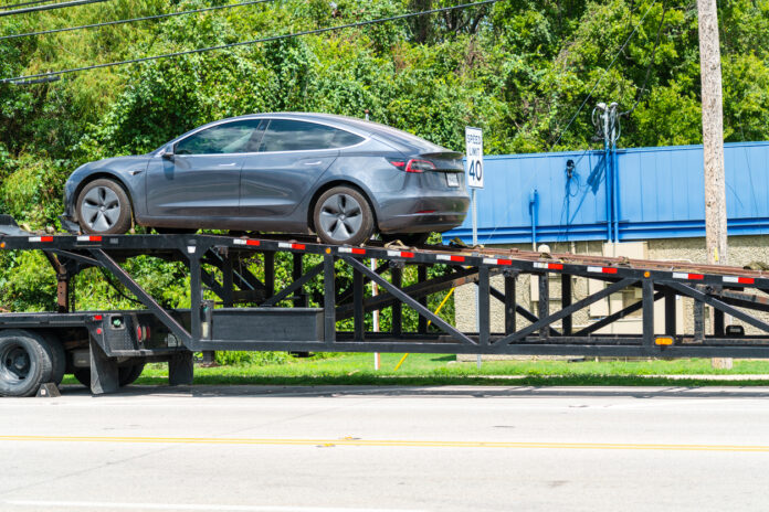 Ein neuer Tesla kommt an und wird vom Sattelschlepper entladen
