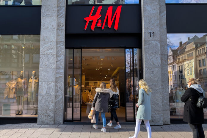 Eine H&M Filiale mit offenen Türen und mehreren Kunden, die den Laden betreten.