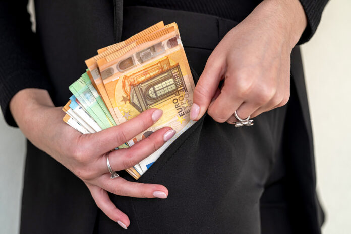 Eine Frau hält Geldscheine in der Hand. Diese Auszahlung steht jetzt an.