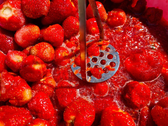Nahaufnahme von zerkleinerten Erdbeeren mit Püree. Herstellung von Erdbeermarmelade