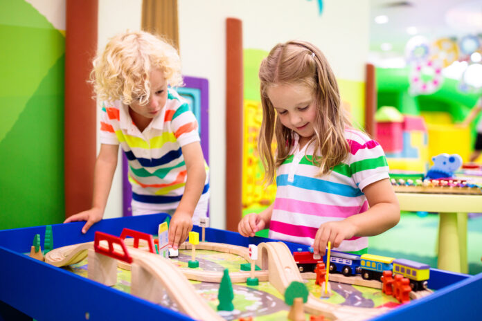 Ein Junge und ein Mädchen spielen in einer Kindertagesstätte.