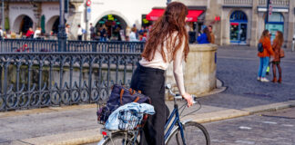 Eine junge Frau mit roten Haaren beim Fahrradfahren.