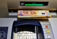 Bargeld wird aus einem Automaten abgehoben.