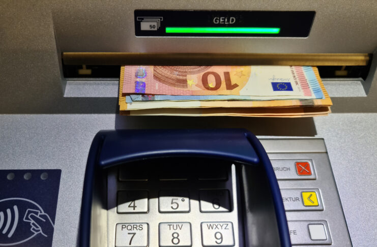 Bargeld wird aus einem Automaten abgehoben.