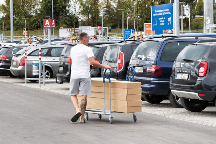 Ein Kunde schiebt seinen Einkauf über den IKEA-Parkplatz