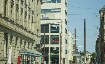 Der Europaplatz in Karlsruhe mit Haltestelle. An einem Tag laufen viele Passanten durch die Karlsruher Innenstadt. Sie kaufen ein, erledigen ein paar Wege und bummeln.