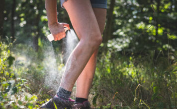 Stechmücken- und Zecken-Spray im Einsatz am Bein eines Wanderers
