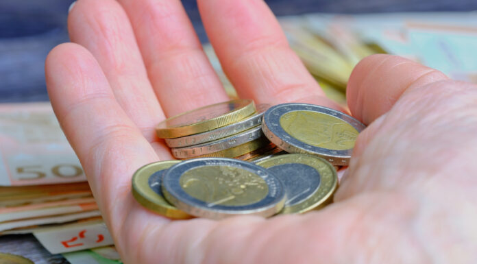Eine Hand hält verschiedene 1-Euro-Münzen und 2-Euro-Münzen