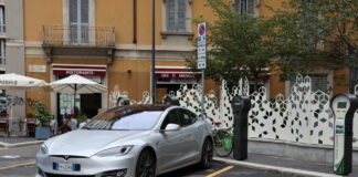 Ein Tesla auf einem Parkplatz für Elektroautos in Italien.