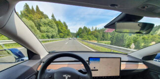 Der Betrachter des Bildes fährt eine leere Autobahn in einem High-Tech-autonomen Tesla-Fahrzeug hinunter.