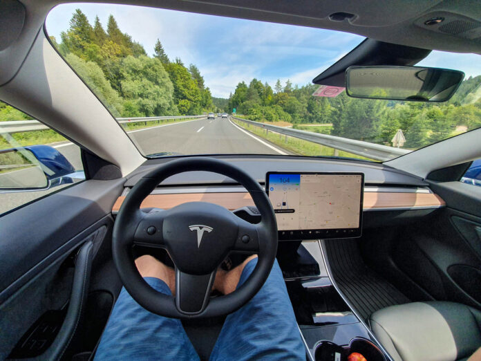 Der Betrachter des Bildes fährt eine leere Autobahn in einem High-Tech-autonomen Tesla-Fahrzeug hinunter.