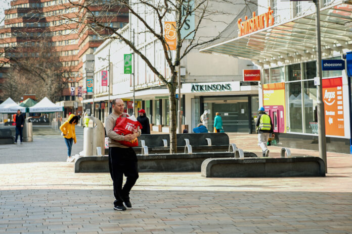 Ein Mann in einer leeren Einkaufsstraße.