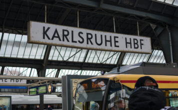 Das Schild vom Karlsruher Hauptbahnhof auf dem Bahnhofsgelände am Bahnsteig