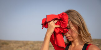 Eine Frau tupft sich mit einem Tuch bei großer Hitze die Stirn ab