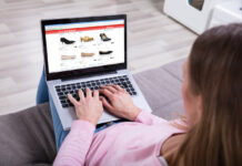 Eine Frau shoppt Schuhe an einem Laptop.