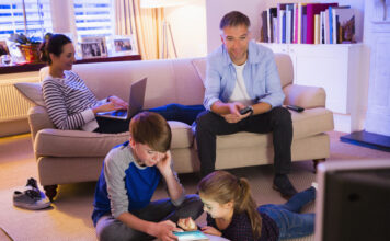 Familie genießt im Wohnzimmer entspannt ihre Medienzeit